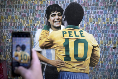 Pelé beija Maradona na bochecha.
