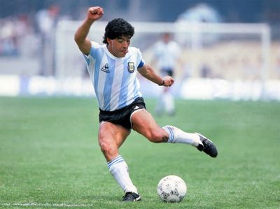 Diego Maradona chutando uma bola.