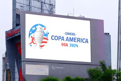 Um grande outdoor, na parte externa de um prédio, com a logo oficial da Copa América.