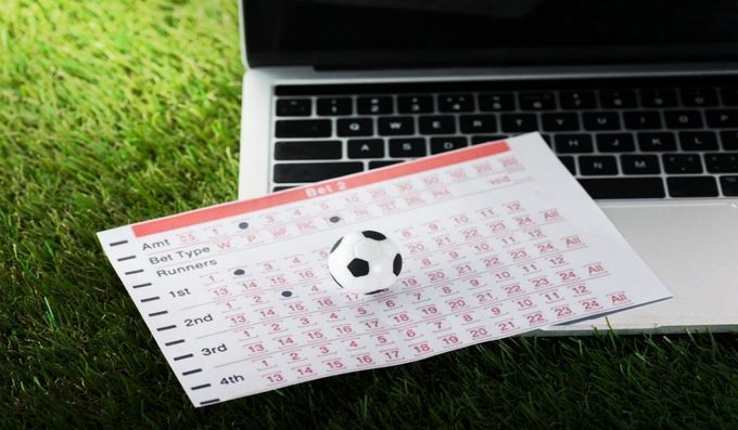 a soccer ball sitting on top of a piece of paper next to a laptop