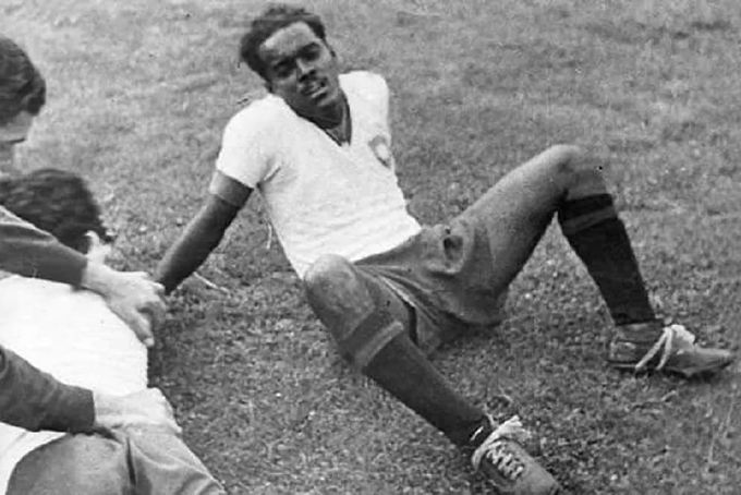 a couple of men sitting on top of a lush green field