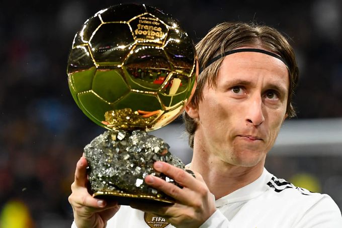 Luka Modric segurando uma Bola de Ouro.