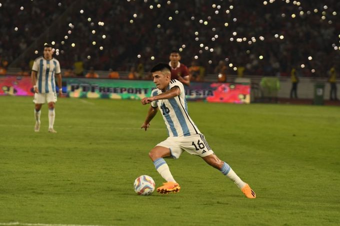 a man kicking a soccer ball on a field