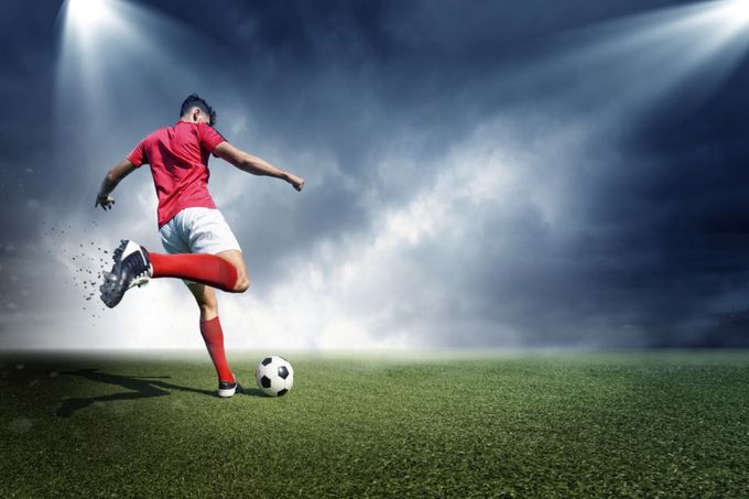 a man kicking a soccer ball on a field