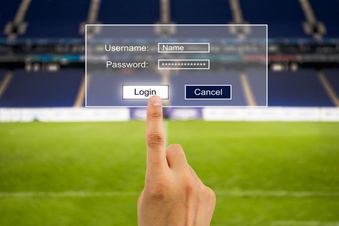 a hand pressing a login button on a soccer field