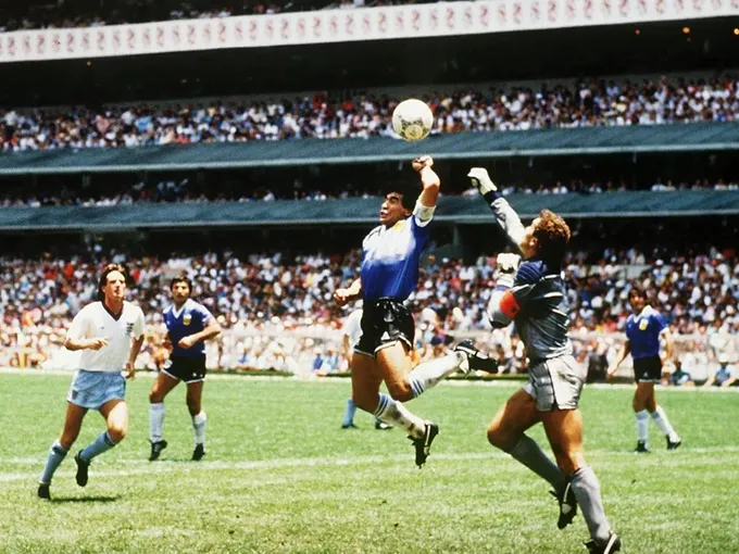Diego Maradona pulando para pegar uma bola.