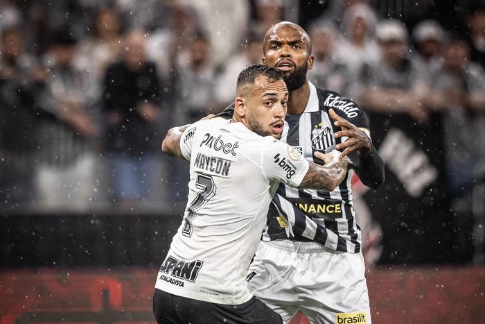 A jogador do Corinthians marca um jogador do Santos durante uma partida