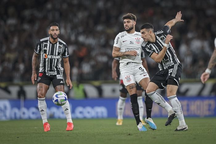 Jogadores do Corinthians e do Atlético Mineiro disputam a bola em campo
