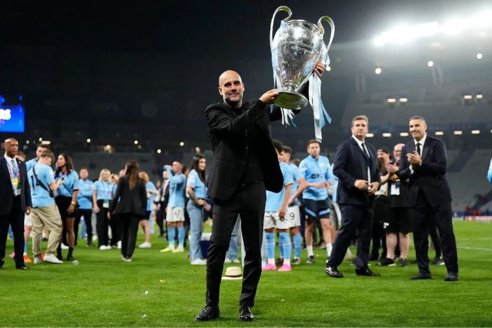 Pep Guardiola segurando um troféu da Liga dos Campeões.