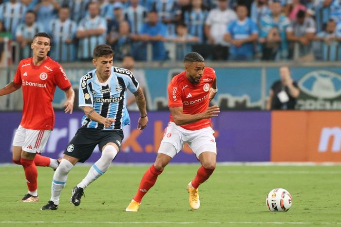 A jogadores do Internacional e do Grêmio disputam a bola durante o jogo.