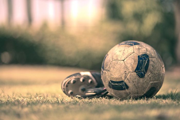 Bola de futebol suja, no gramado