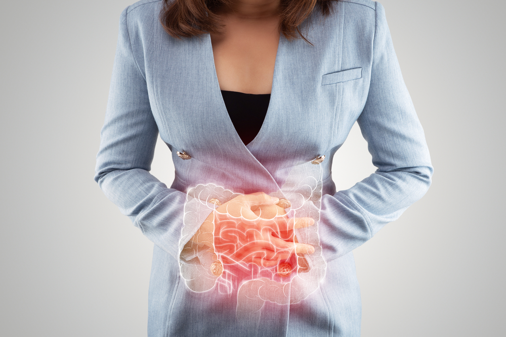 Woman holding her stomach with a graphic illustration of inflamed bowels