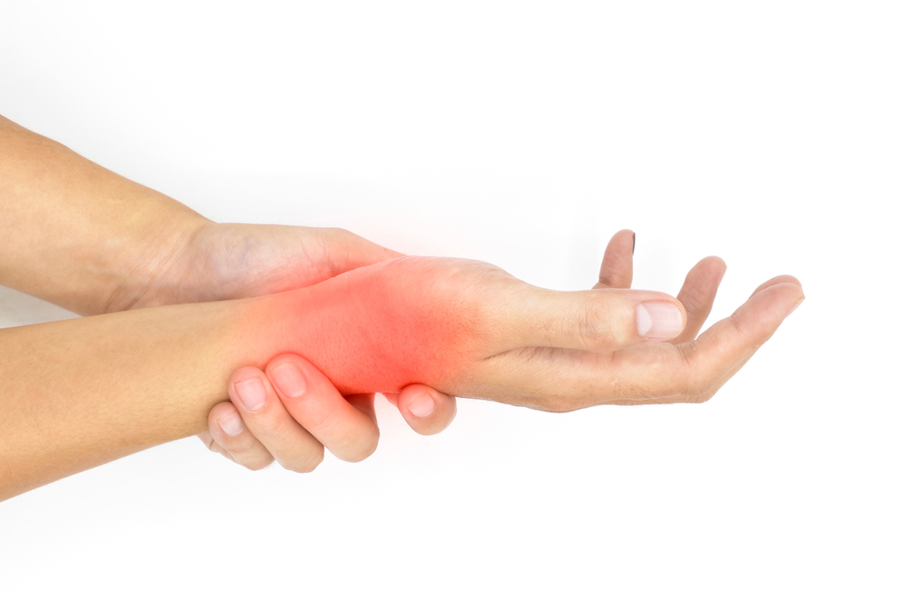 Close-up of female hands with a red colored area signifying an area of pain against a white background