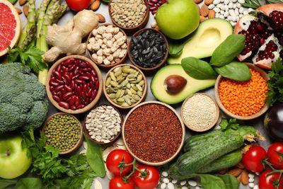Top view of healthy foods like seeds, vegetables, and fruits arranged on a table