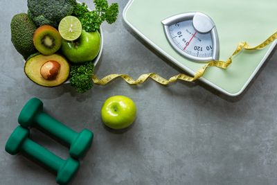 Fruits, weights, and a scale on a gray background 