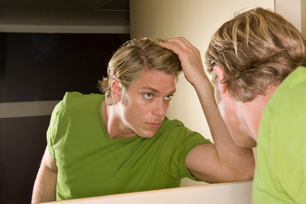 Man fixing his hair looking in the mirror