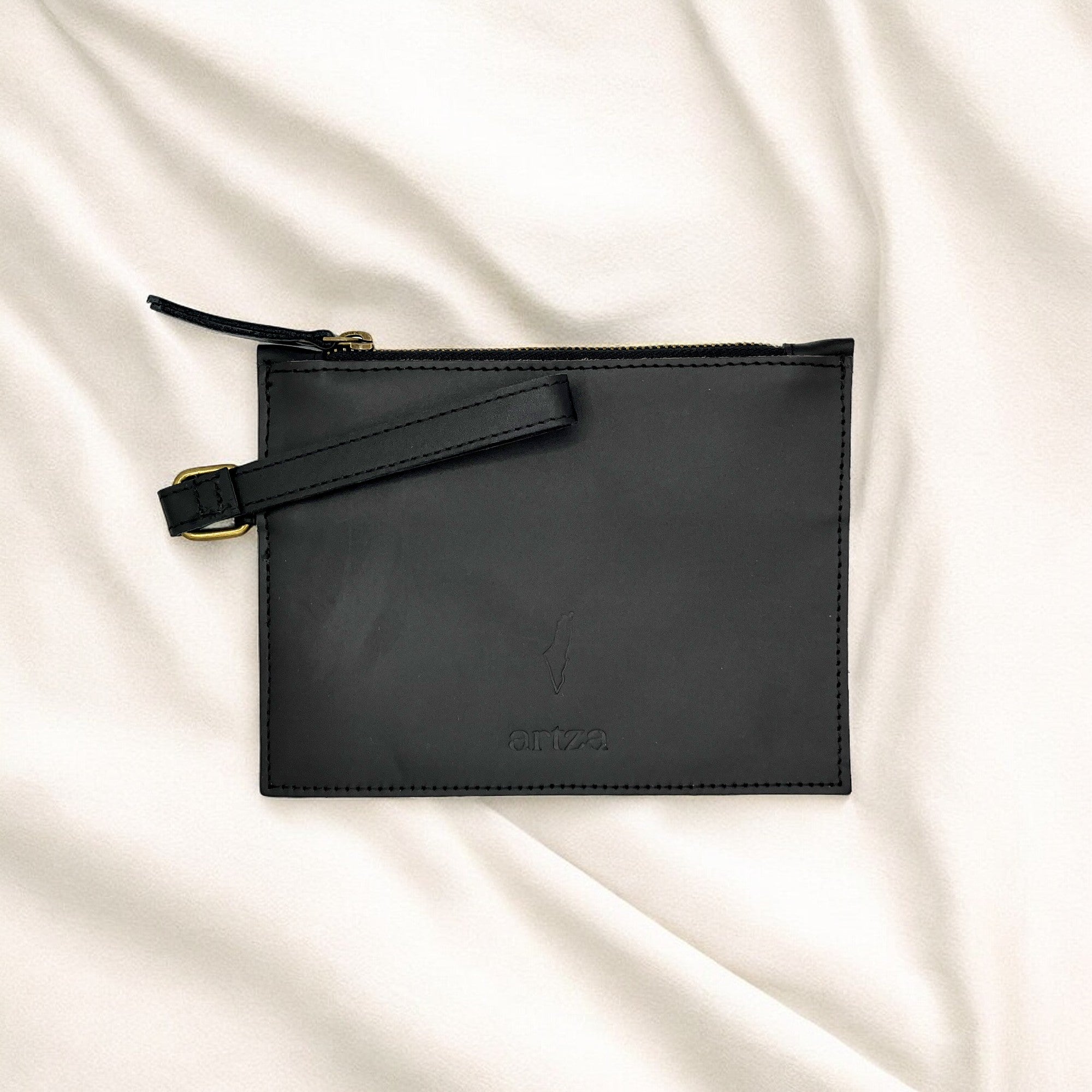 a black leather pouch on a white sheet