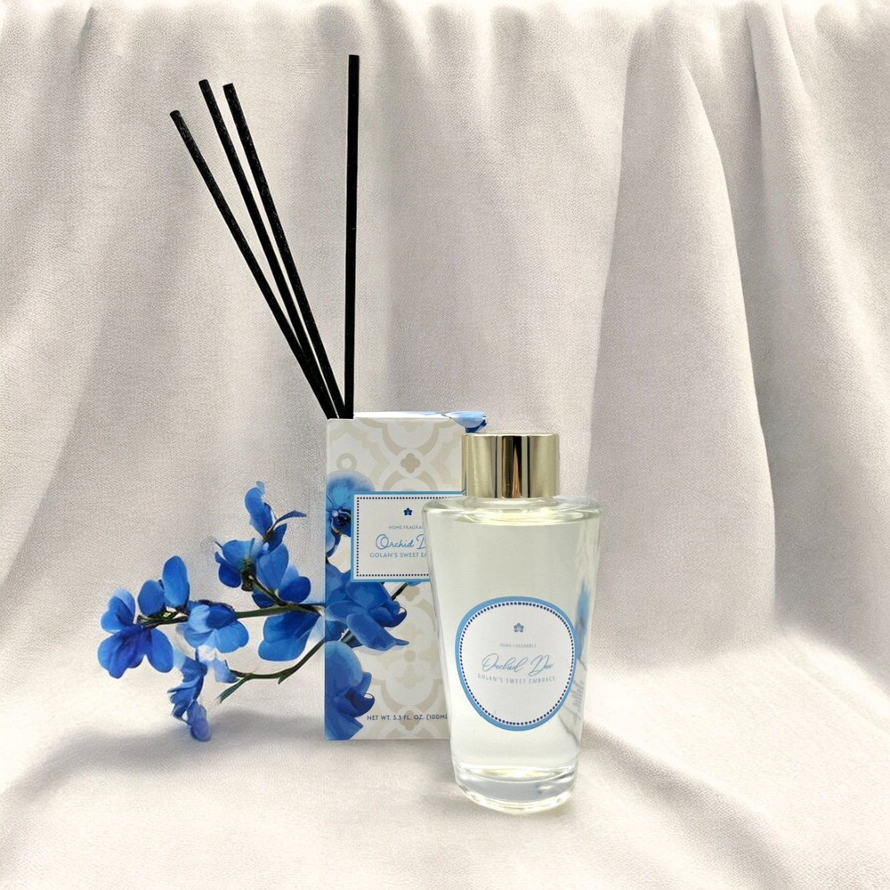 a bottle of perfume next to a blue flower