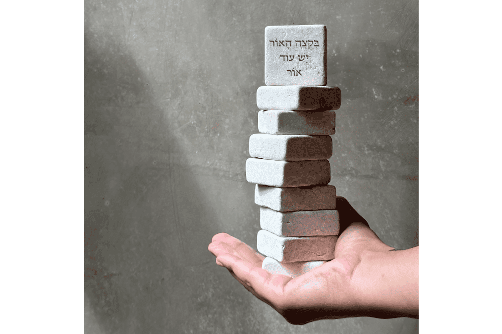 a hand is holding a stack of bricks