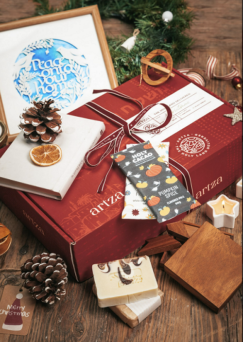 Closed Artza Christmas box with decorations and products surrounding it