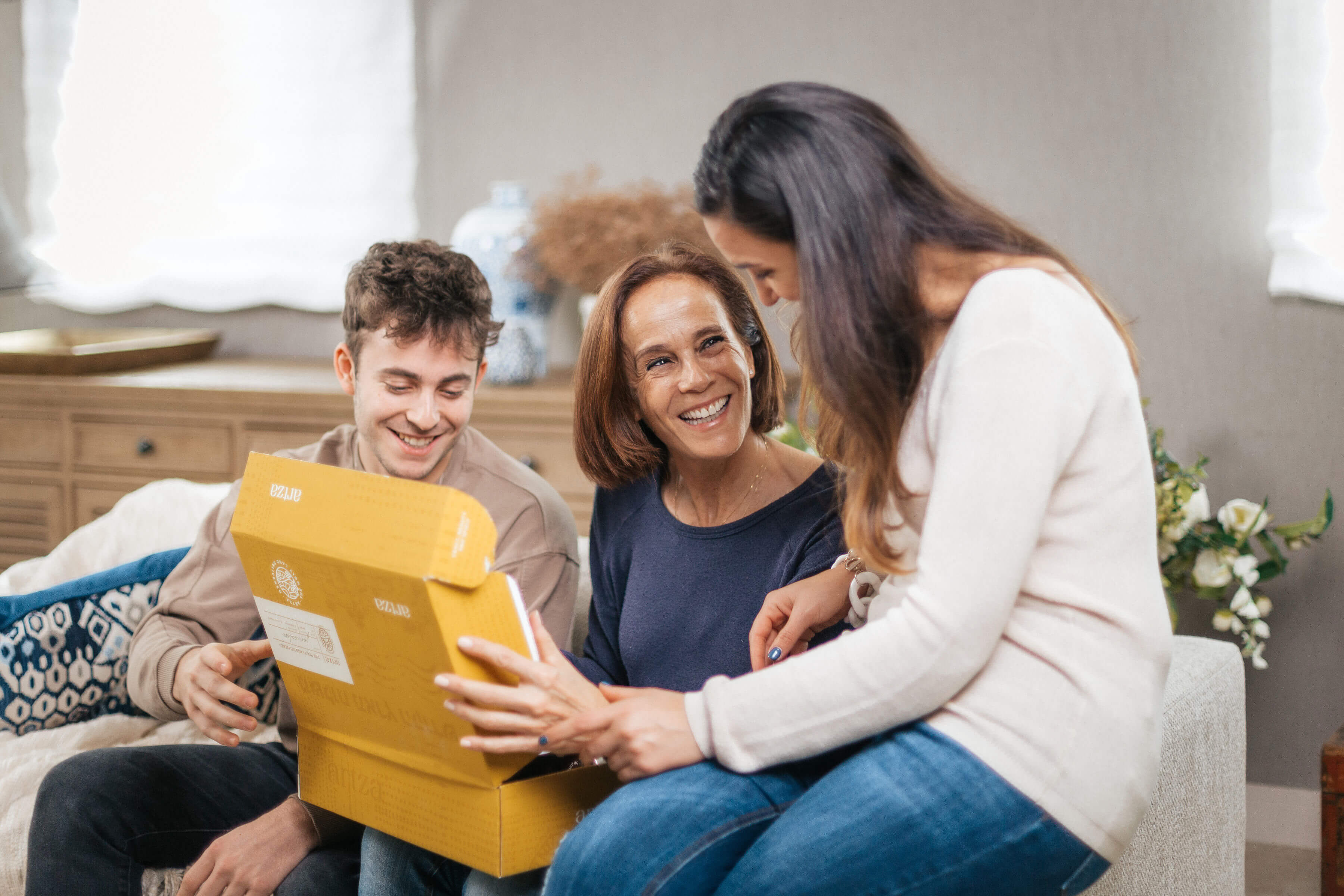 a group of pmother son friend meaningful faith christian gift israel box eople sitting on a couch looking at a box