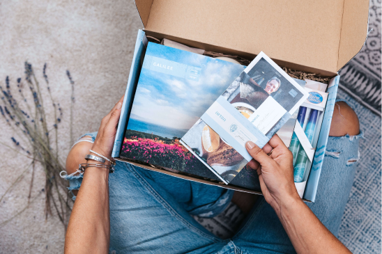 a woman is holding a box full of photos