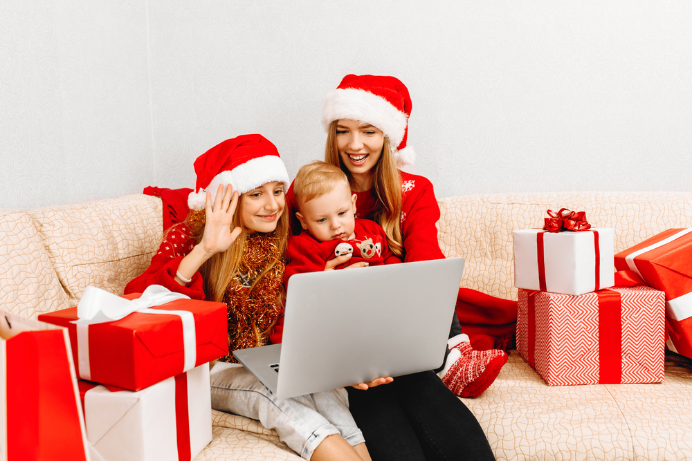 Family in Christmas hats in front of a laptop