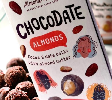 a box of chocolate almonds next to a pile of almonds