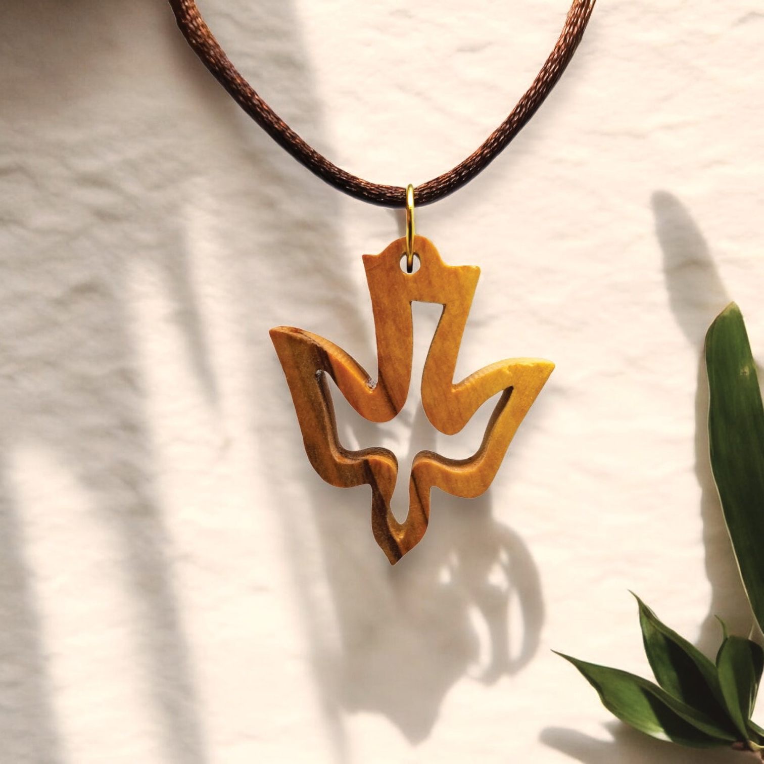 a necklace with a wooden design hanging from a cord