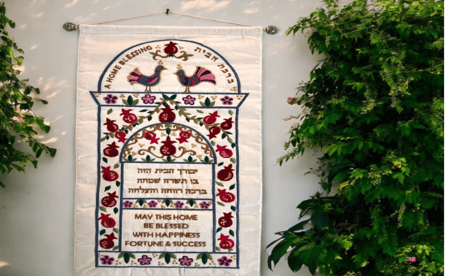 a wall hanging on a wall with flowers and birds on it