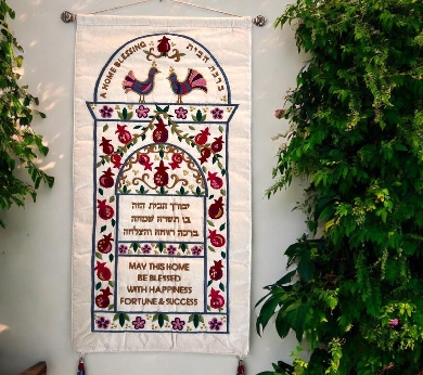 a wall hanging on a wall with a cross stitch pattern