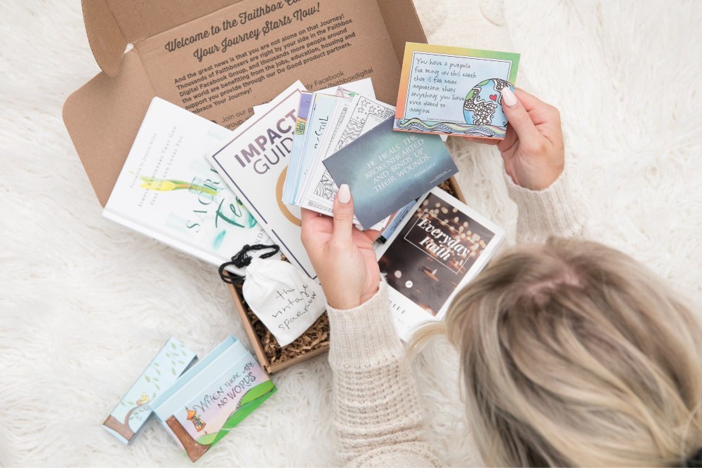 a woman is holding a box of books