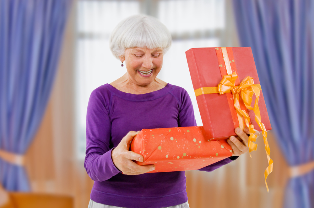 Grandmother opening a Christmas gift