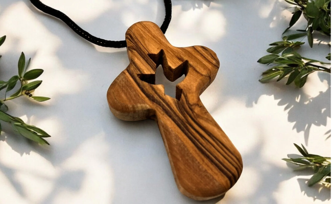 a wooden cross on a black cord on a white surface