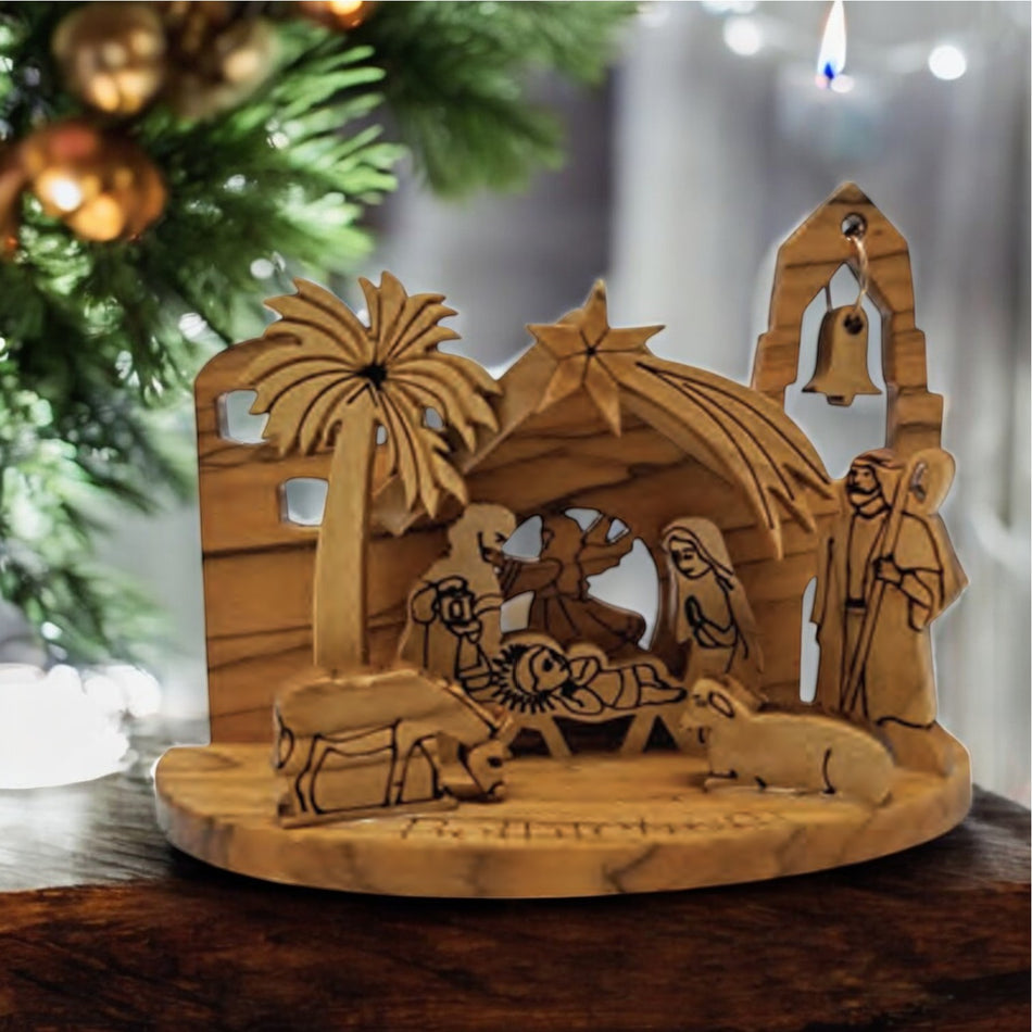 a wooden nativity scene with a christmas tree in the background