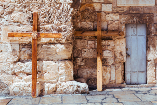 Two large wooden crosses against a wall 
