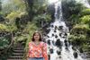 a woman standing in front of a waterfall