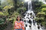 a woman standing in front of a waterfall