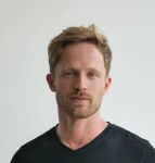 a man in a black shirt is posing for a picture