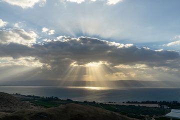 the sun is shining through the clouds over the ocean