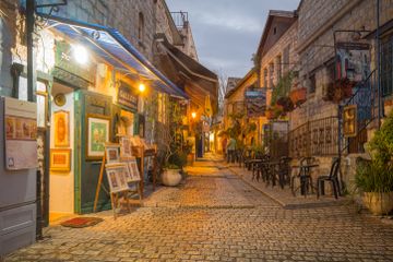 a cobblestone street lined with tables and chairs