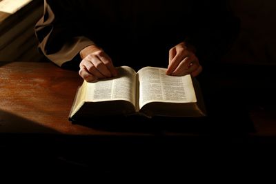 A person sitting at a table with an open Bible.