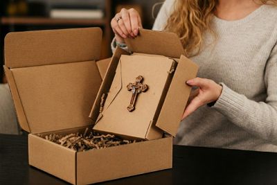 A woman opening a box with a cross on it.