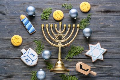 Cookies for Hanukkah celebration with menorah and Christmas decor on wooden background