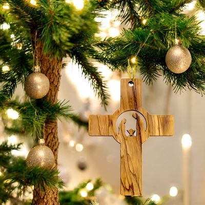 a wooden cross hanging from a christmas tree