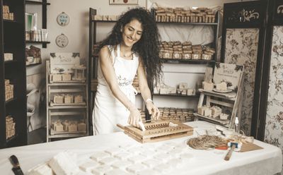 a woman standing in front of a table cutting a cake