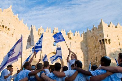 a group of people holding flags in front of a castle