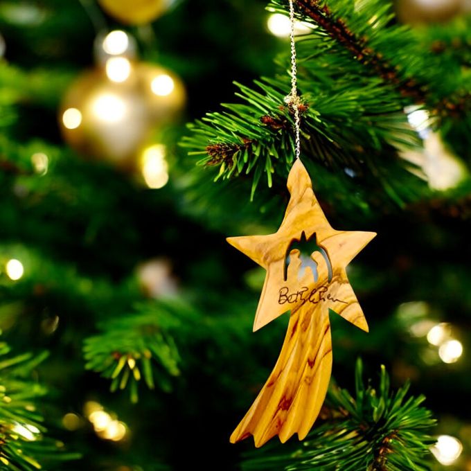 a wooden star ornament hanging from a christmas tree