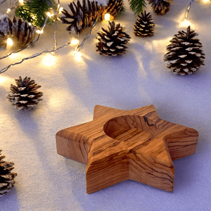 a wooden star ornament sitting on top of a snow covered ground