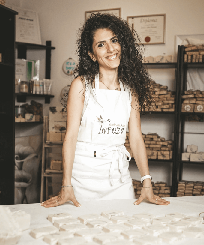 a woman standing in front of a table with a lot of cookies on it